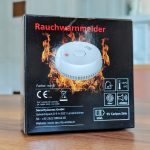 Rückseite einer Rauchwarnmelder-Verpackung mit Flammenmotiv, technischen Angaben und Hersteller SecurityAccess GmbH aus Lanzenkirchen