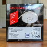 Rückseite einer Rauchwarnmelder-Verpackung Modell ZA208 mit Hersteller- und Importeurinformationen sowie VdS- und CE-Kennzeichnung