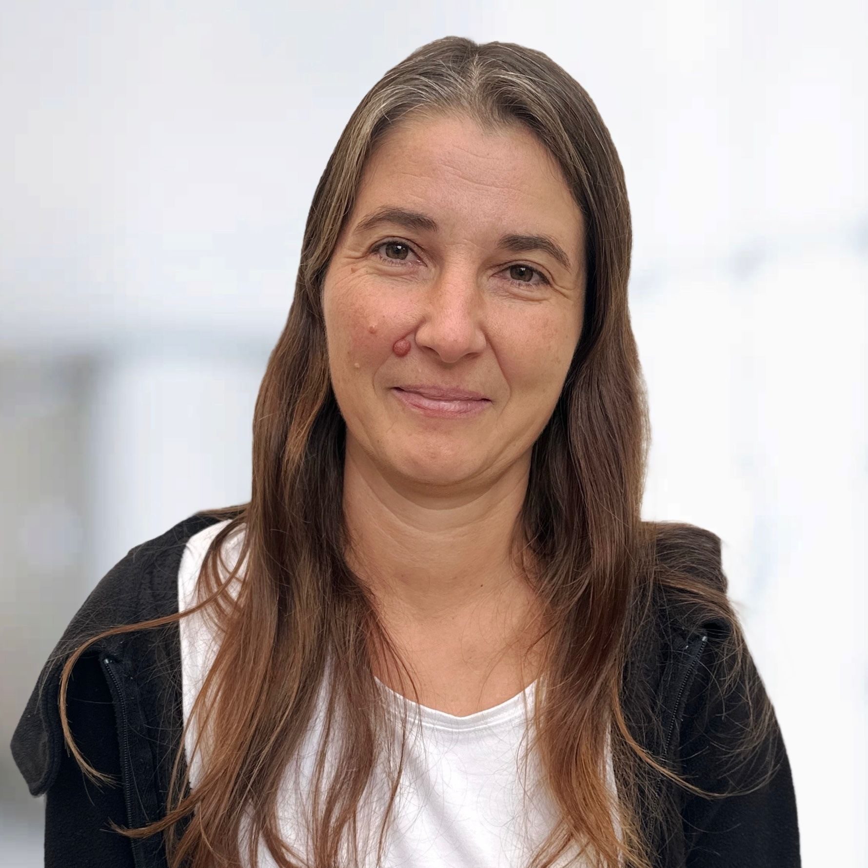 Porträt von Manuela Feurer, Mitarbeiterin des Teams Grieer Rauchfangkehrermeister im Burgenland, mit braunen Haaren und freundlichem Ausdruck