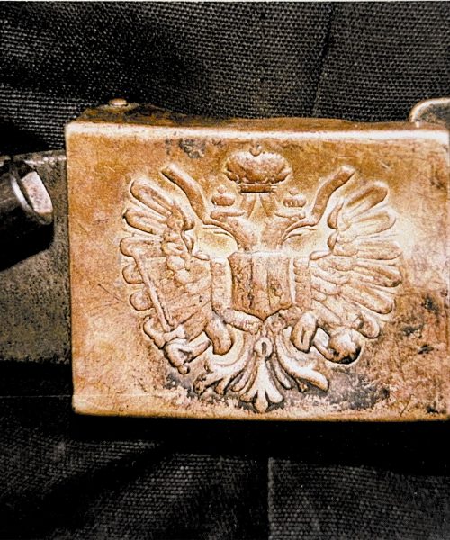 Nahaufnahme einer alten metallenen Gürtelschnalle mit geprägtem Doppeladler, traditionelles österreichisches oder kaiserliches Symbol