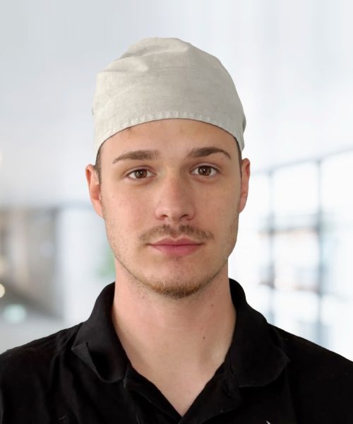 Porträt von Kai Grieer, Mitarbeiter des Teams Grieer Rauchfangkehrermeister im Burgenland, in schwarzem Firmenpolo mit grauer Kopfbedeckung